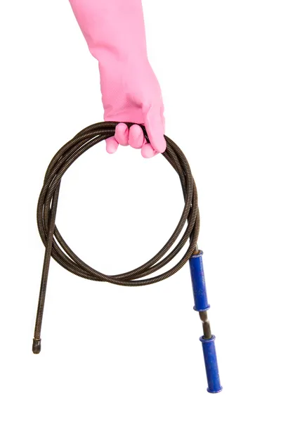Mano femenina con guante rosa sostiene una estaca de drenaje, asegurando el correcto funcionamiento del sistema con el chicote de freno de mano ajustado.